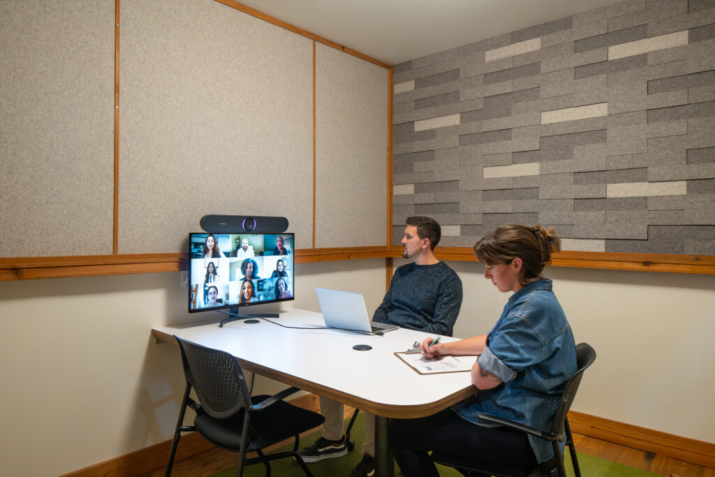 2 people on a video conferencing call in a meeting room.